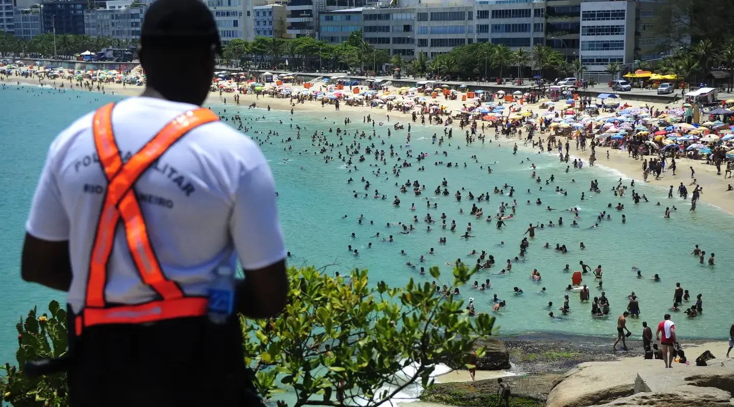 Do alto da pedra do Arpoador, policial militar acompanha a movimentação na praia. Foto Divulgação PM