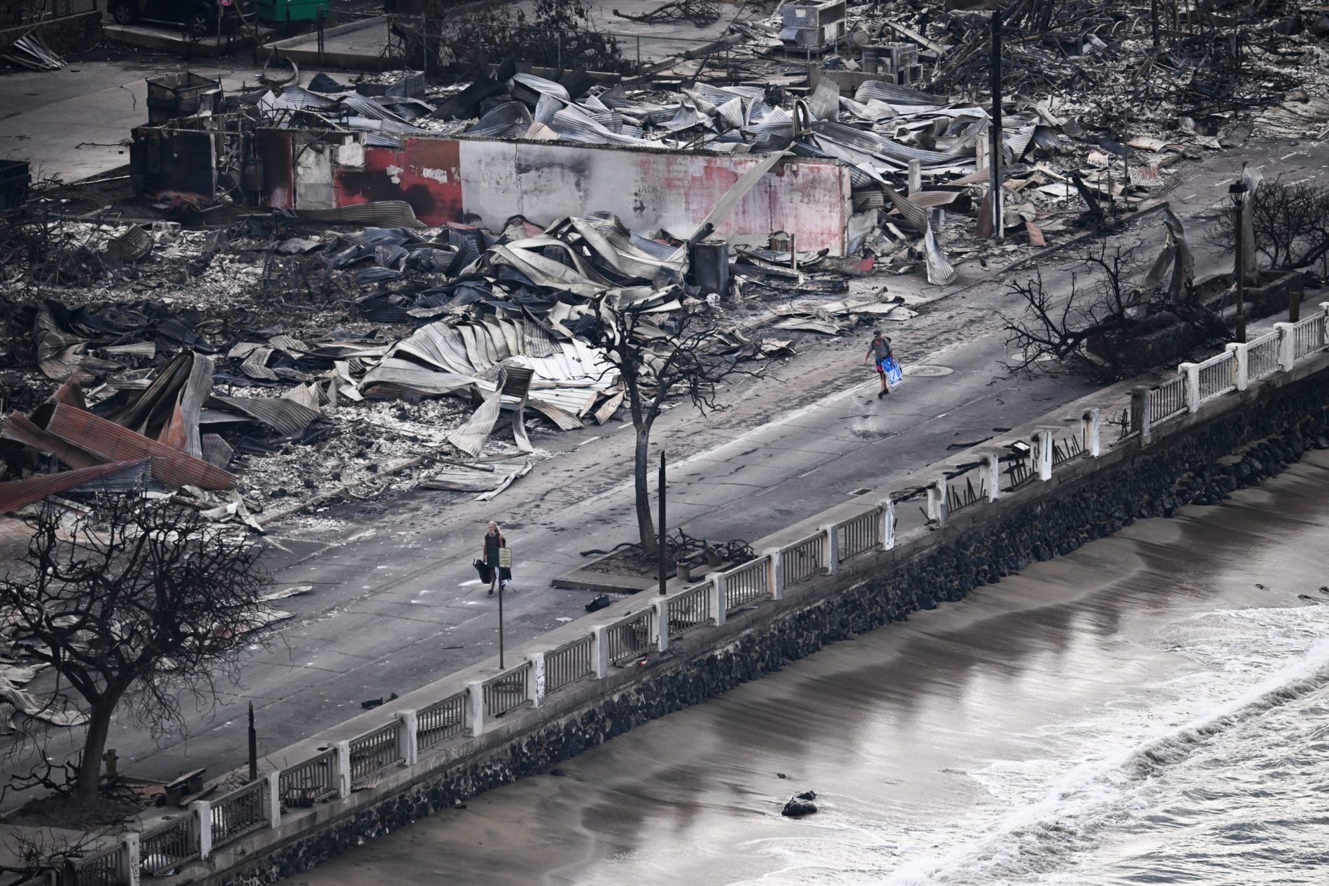 Imagem aérea mostra uma pessoa caminhando pela Front Street, passando por edifícios destruídos e totalmente queimados em Lahaina, no Havaí, após incêndios florestais deixarem, pelo menos, 36 mortos. Foto Patrick T. Fallon/AFP. Agosto/2023