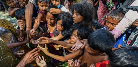Refugiados Rohingya recém-chegados recebem alimentos doados por pessoas em uma praia em Laweueng, distrito de Pidie, na província indonésia de Aceh. Foto Chaideer Mahyussin/AFP