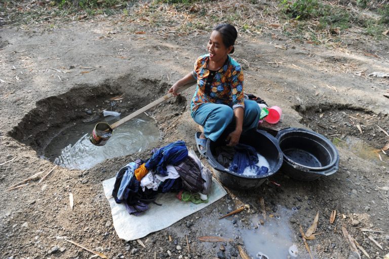 Mulher lava roupas com água vinda de um buraco cavado por uma nascente em um rio seco na aldeia Ketro de Grobogan, Java Central, Indonésia. Foto Dasri Roszandi/Anadolu Agency via AFP