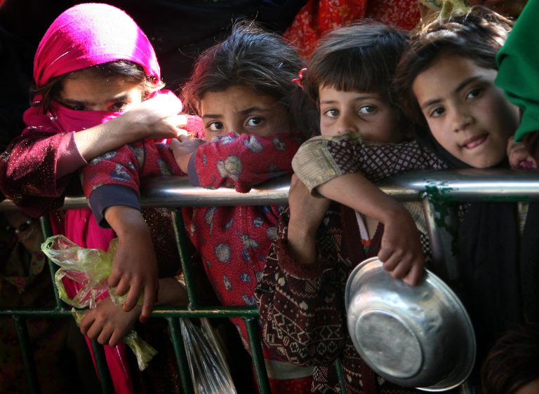 Meninas paquistanesas fazem fila para receber alimentos doados no pátio do santuário do Sufi Saint Bari Imam, em Islamabade. O país segue com um dos piores IDHs do mundo. Foto Behrouz Mehri/AFP