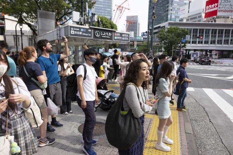 Pedestres aguardam a abertura do sinal de trânsito em uma esquina de Tóquio. O país vem apresentando um decrescimento populacional desde 2010. Foto Stanislav Kogiku/APA via AFP
