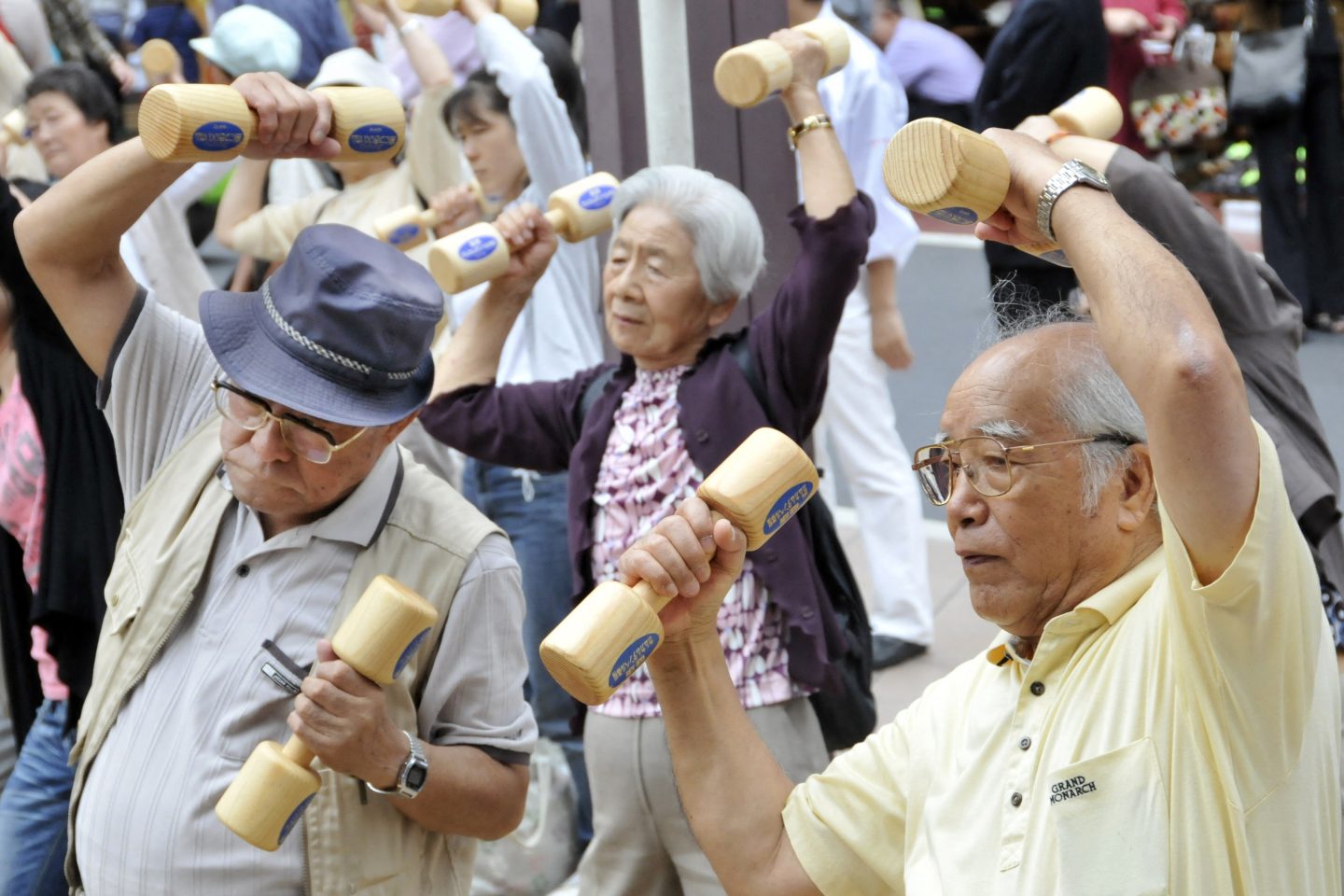 Idosos se exercitam com halteres de madeira no terreno de um templo em Tóquio, para celebrar o Dia do Respeito ao Idoso no Japão. Pessoas de 50 anos e mais já representam metade da população do país. Foto Yoshikazu Tsuno/AFP
