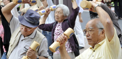 Idosos se exercitam com halteres de madeira no terreno de um templo em Tóquio, para celebrar o Dia do Respeito ao Idoso no Japão. Pessoas de 50 anos e mais já representam metade da população do país. Foto Yoshikazu Tsuno/AFP