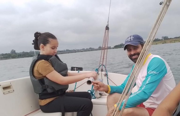 Ana Clara, 9 anos, cega de nascimento e seu instrutor: modo peculiar de 'ver' ao velejar proporcionado pelo projeto Vela Adaptada (Foto: Divulgação)