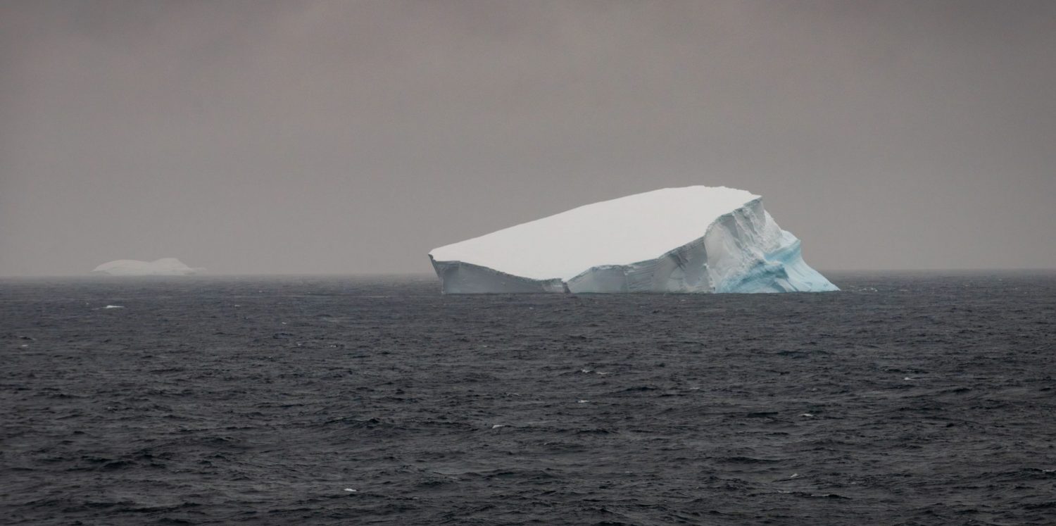 Foto colorida de placa de gelo derretendo em oceano na Antártica