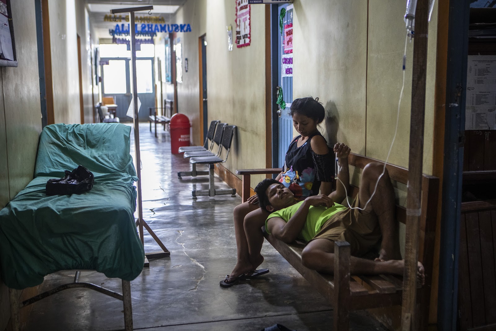 Jovem espera por atendimento em corredor de posto de saúde em Mazán: cenário de pobreza e vulnerabilidade em área rica em petróleo (Foto: Marco Garro / InfoAmazonia)
