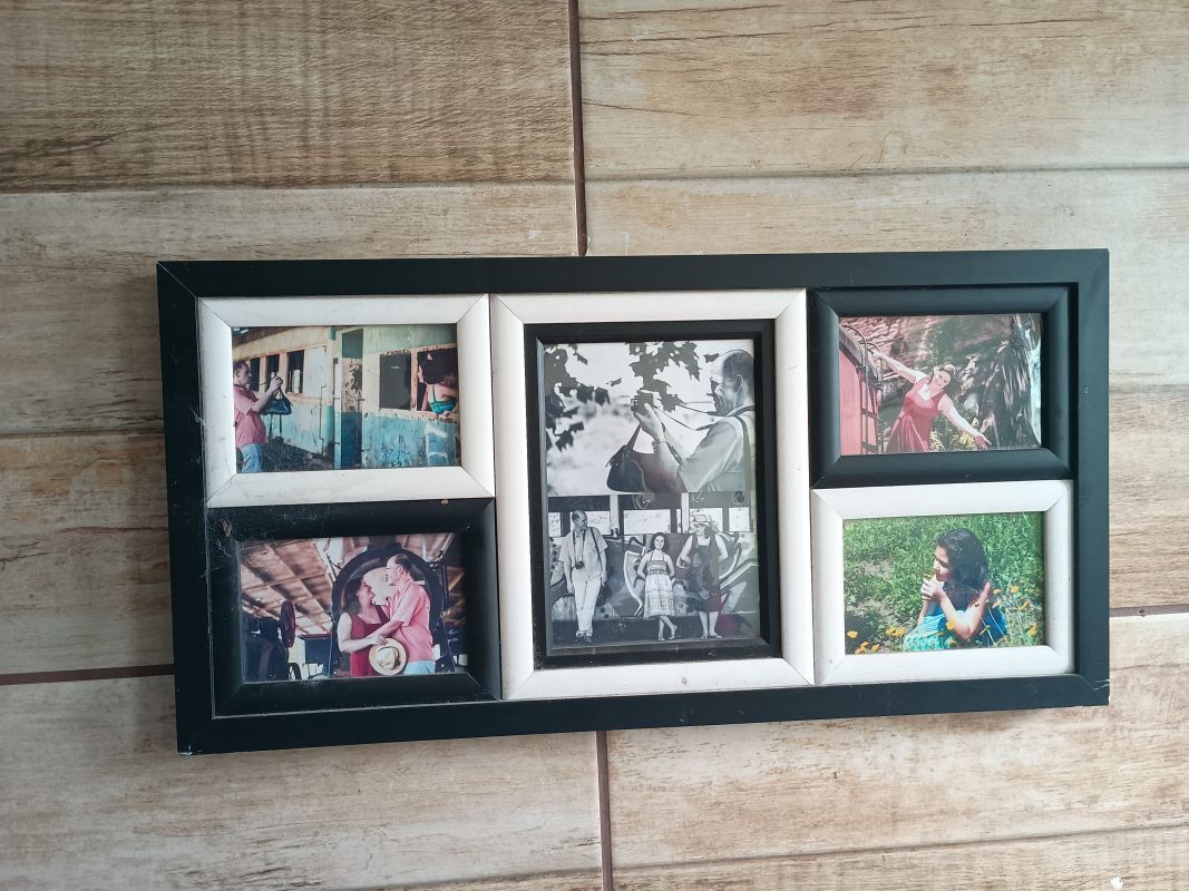 Foto colorida de quadros com fotos pendurado em parede da casa de Suzi