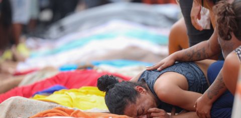 Mulher chora ao lado de corpos enfileirados em praça da Zona Norte do Rio: número de mortos na chacina mais letal da história do estado passa de 100 (Foto: Tomaz Silva / Agência Brasil)