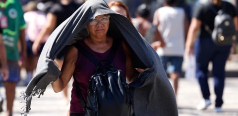 Idosa tenta se proteger do sol em dia de calor de mais de 40 graus no Rio: pesquisa apontou que o calor extremo tem um impacto comparável ao tabagismo e consumo excessivo de álcool na aceleração do envelhecimento (Foto: Tânia Rego / Agência Brasil - 17/02/2025)