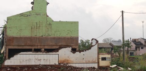 Foto colorida que mostra escombros de casa e, ao fundo, outras residências no bairro Navegantes, em Arroio do Meio