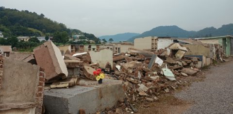 Foto colorida de escombros e túmulos revirados no cemitério destruído pela enchente em Muçum