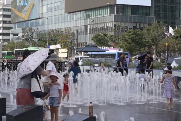 Crianças se refrescam em chafariz em Seul: Coreia do Sul enfrenta temperatura recorde e mais de 20 mortes por calor (TV AL Jazeera / Reprodução)