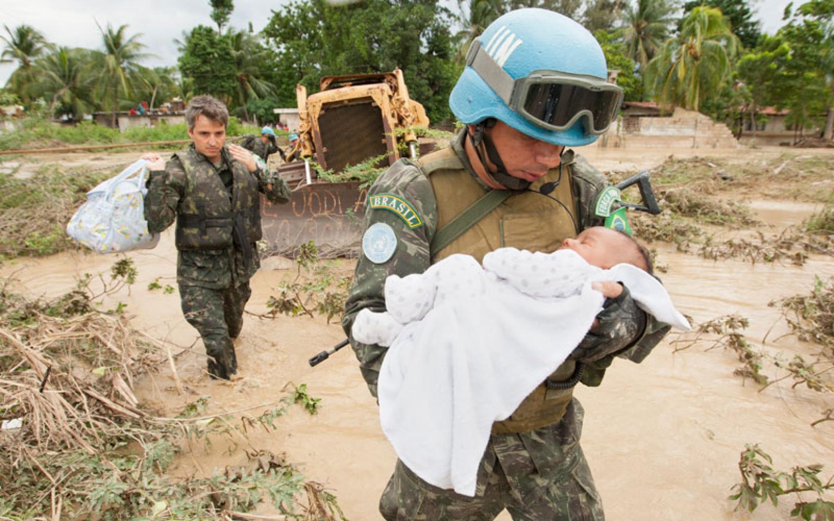 Soldado brasileiro resgata um bebê durante a tempestade tropical Noël no Haiti, em 2007: força internacional da ONU no país abalado por furacões, terremotos e violência (Foto: Marco Dormino / ONU)