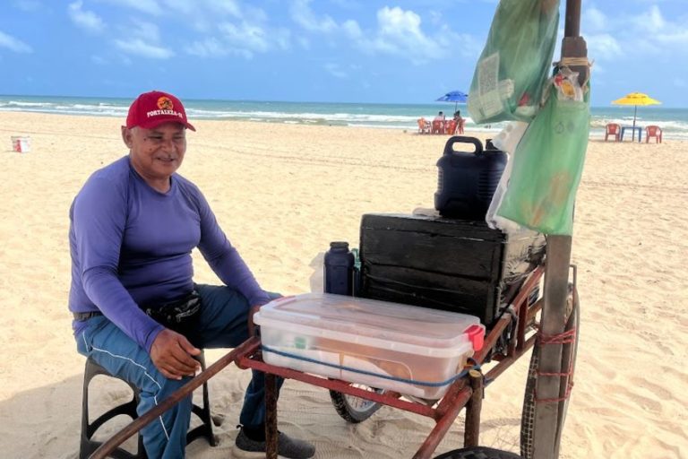 Ambulante trabalha sob o sol na Praia do Futuro: aumento das temperaturas e a falta de áreas com sombra, pontos de hidratação e infraestrutura mínima tornaram a rotina dos ambulantes ainda mais cansativa e insegura (Foto: Arquivo Pessoal)