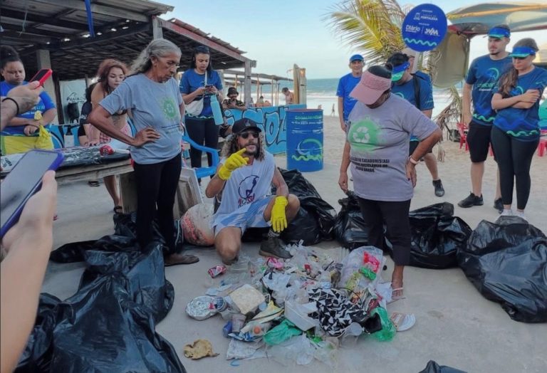 André Comaru, agachado, ativistas do Nossa Iracema e catadores de recicláveis em ação na Praia de Fortaleza: lixo da praia carregado para o oceano (Foto: Coletivo Nossa Iracema)